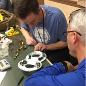 Fix it clinic volunteer helps a resident fix a broken item.