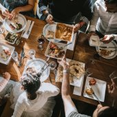 Image of family at a table enjoying a Thanksgiving meal together.