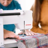 Image of person mending a clothing item with a sewing machine. 