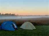Two tents with fog in the background. 
