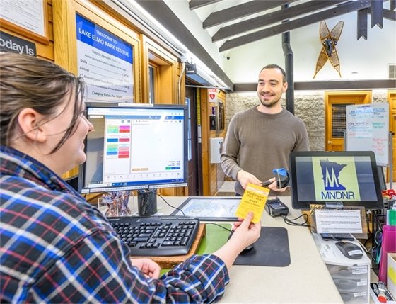 Photo of a staff member helping a member of the public.