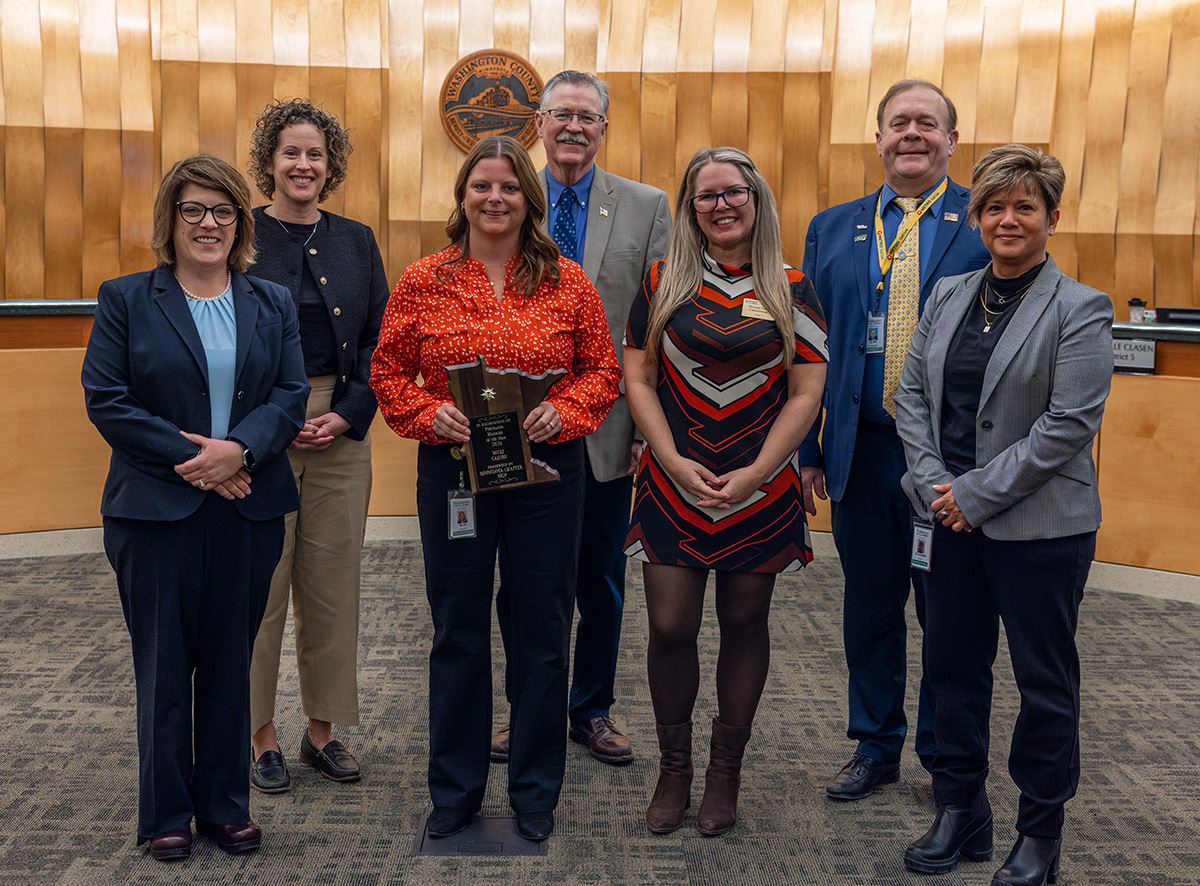 Washington County Procurement Manager Nicki Castro holds the award among commissioners.